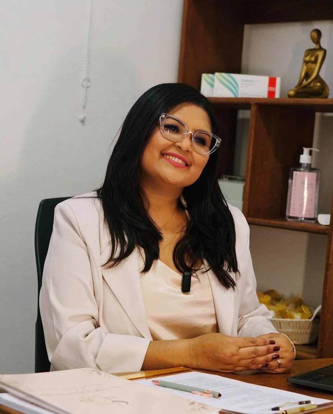 Soneide de Jesus Oliveira, enfermeira, sorrindo à mesa do consultório em Ilhabela
